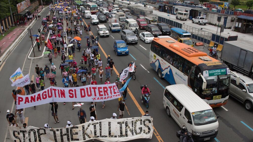 Protestors next to a busy road in the Philippines