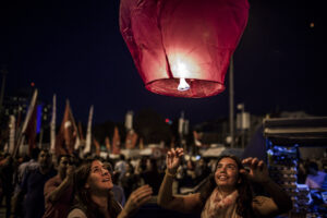 Women release a lit lantern into the night air as large crowds of protestors gather in Gezi Park and Taksim Square.